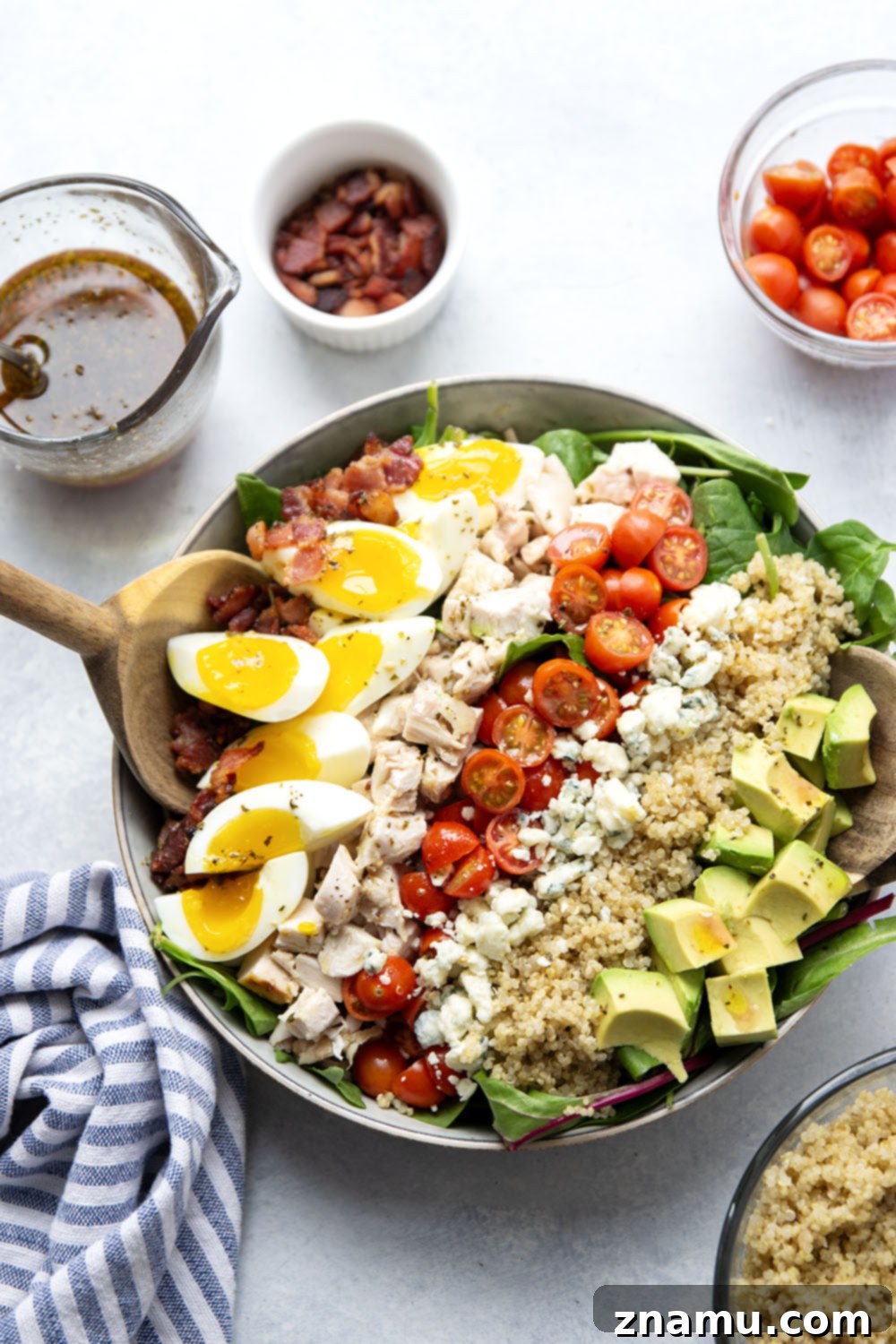 Chicken Quinoa Cobb Creation 2 A beautifully arranged Chicken Quinoa Cobb Salad with fluffy quinoa, diced chicken, eggs, avocado, blue cheese, bacon, and tomatoes, drizzled with red wine vinaigrette.