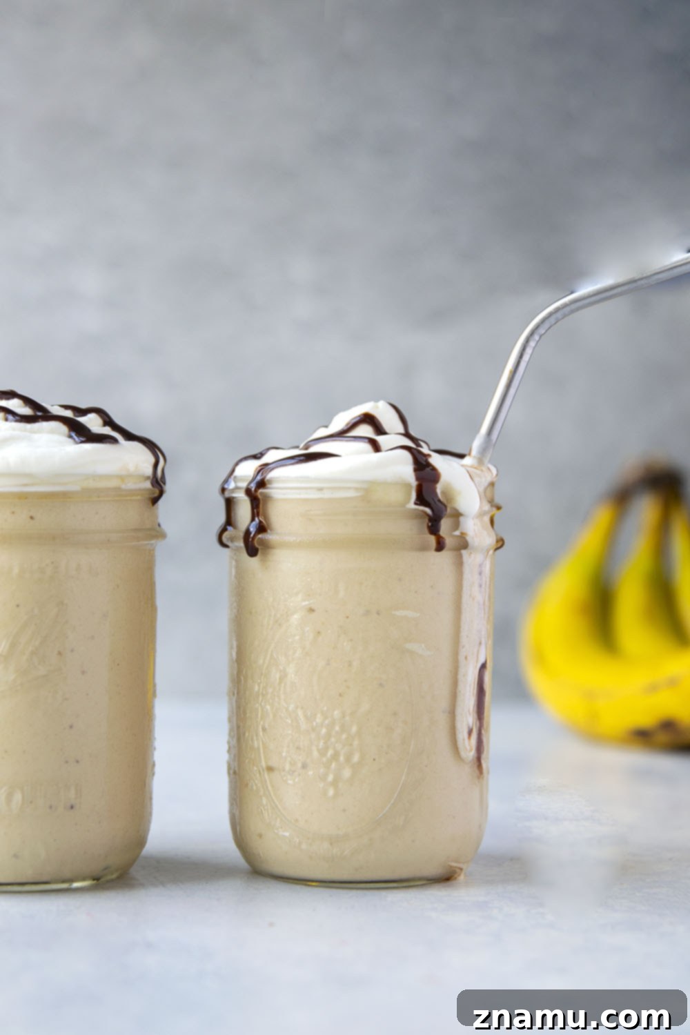 Peanut Butter Banana Blast 5 A vibrant peanut butter banana shake poured into a tall glass, ready to be enjoyed.