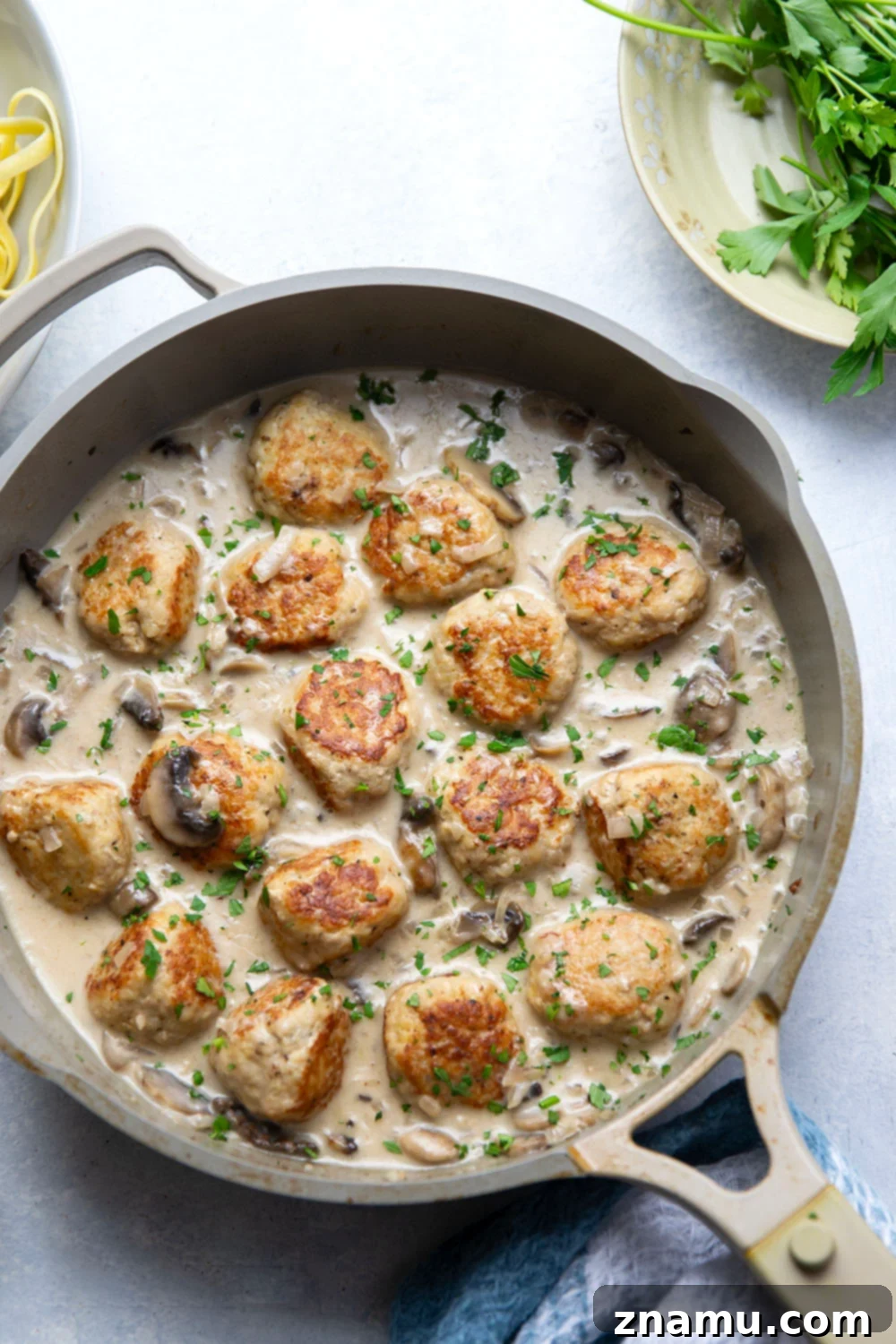 Flavorful Chicken Marsala Meatballs 4 Close-up of a chicken marsala meatball with sauce and parsley garnish.