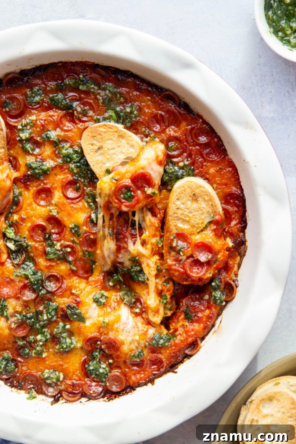 Gooey Baked Pesto Pizza Dip 6 This baked pizza dip features layers of gooey cheese, pizza sauce, mini pepperoni, and drizzles of fresh pesto on top. Serve this crowd-pleasing dip with lots of toasted bread for dipping.