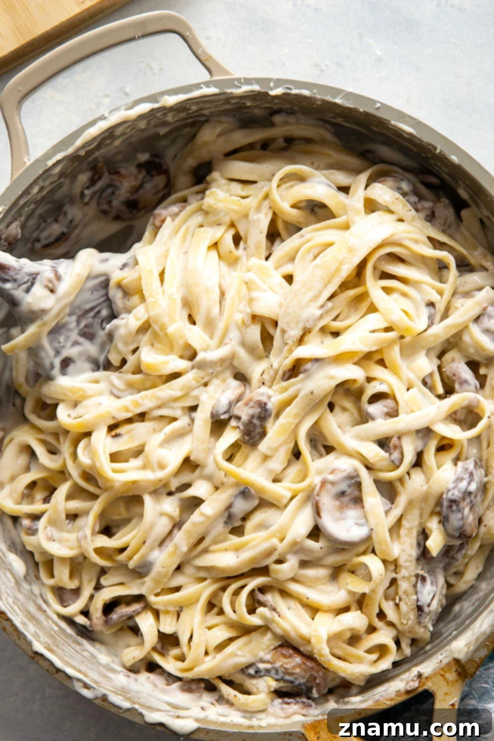 Velvety Asiago Shiitake Alfredo Fettuccine 3 Close-up of creamy Asiago Shiitake Mushroom Fettuccine Alfredo pasta in a pan, ready to serve.