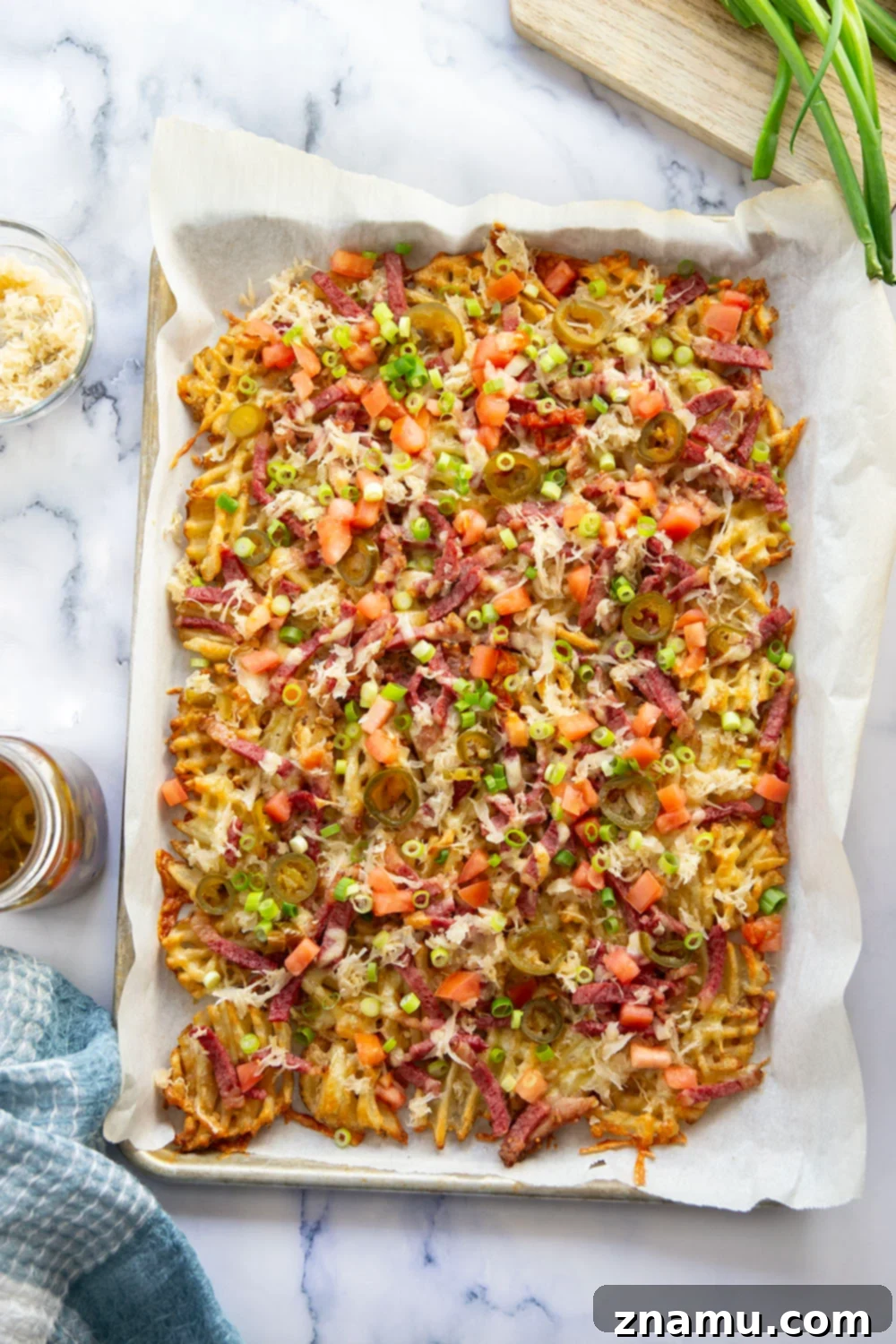 Reuben Nachos 2 These corned beef nachos feature waffle fries that are loaded down with Irish cheddar cheese, corned beef, and tons of toppings for a fun twist on nachos!