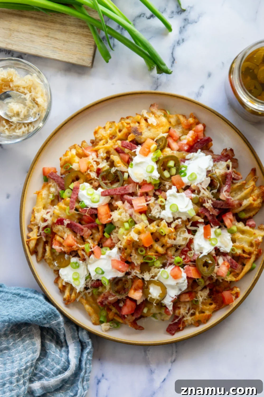 Reuben Nachos 3 These corned beef nachos feature waffle fries that are loaded down with Irish cheddar cheese, corned beef, and tons of toppings for a fun twist on nachos!