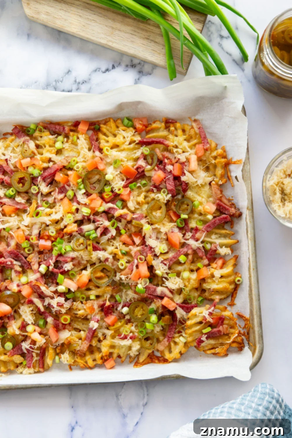 Reuben Nachos 4 These corned beef nachos feature waffle fries that are loaded down with Irish cheddar cheese, corned beef, and tons of toppings for a fun twist on nachos!