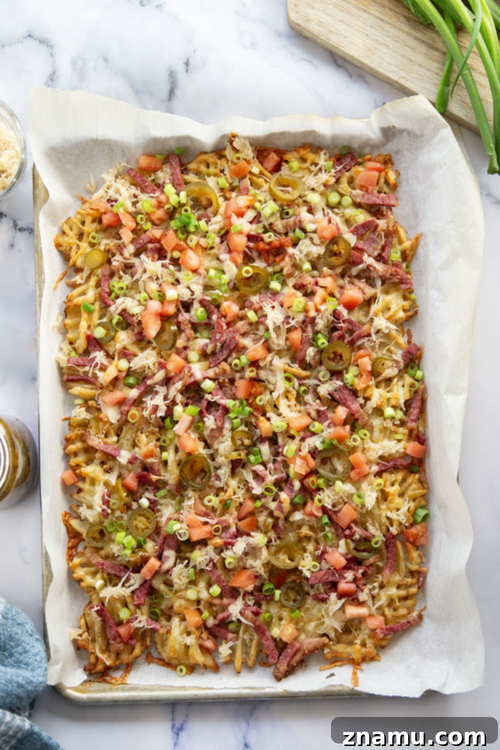 Reuben Nachos 6 These corned beef nachos feature waffle fries that are loaded down with Irish cheddar cheese, corned beef, and tons of toppings for a fun twist on nachos!