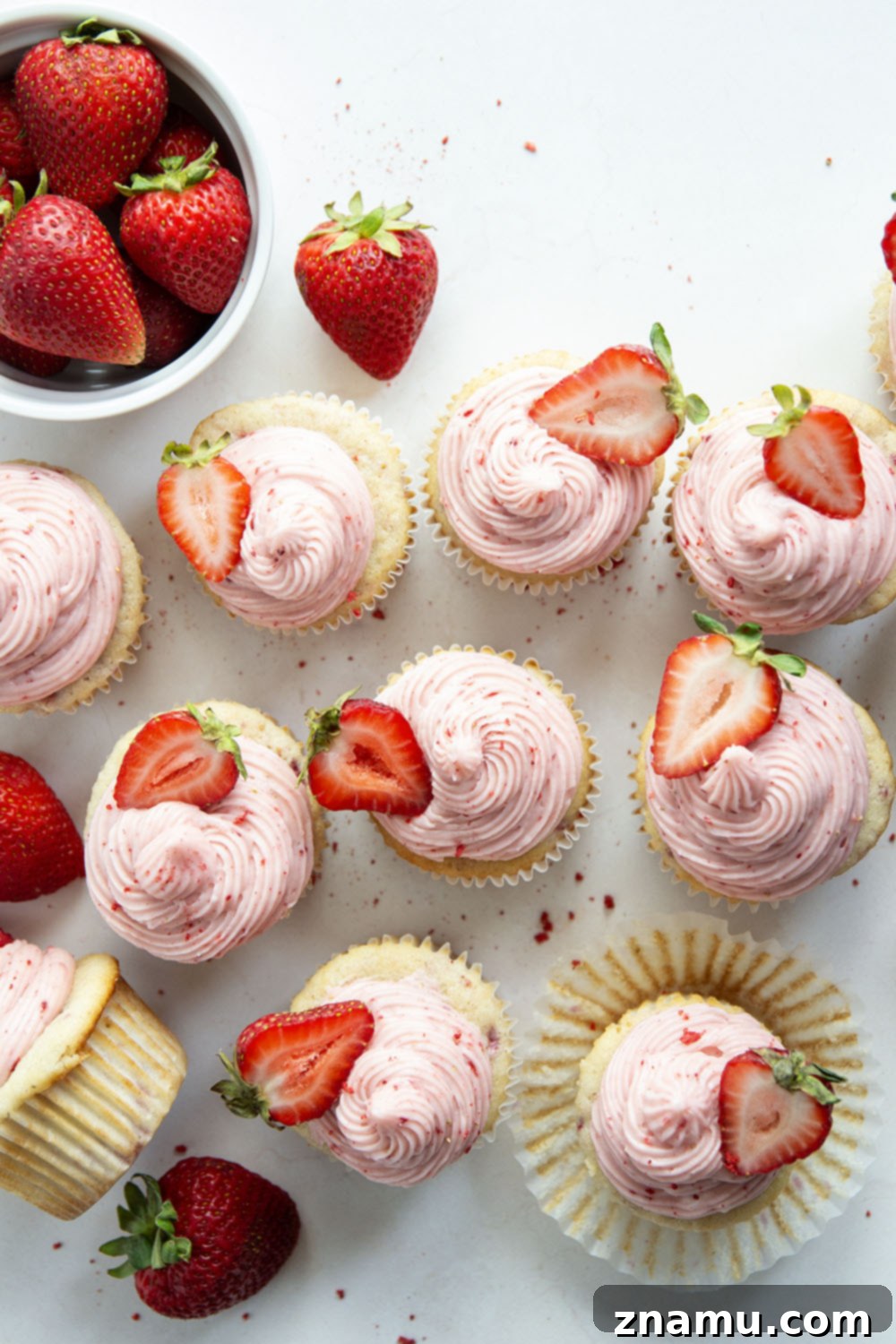 Strawberry Cream Cheese Cupcakes 4 Assortment of strawberry cupcakes, some with fresh strawberry garnish, arranged artfully