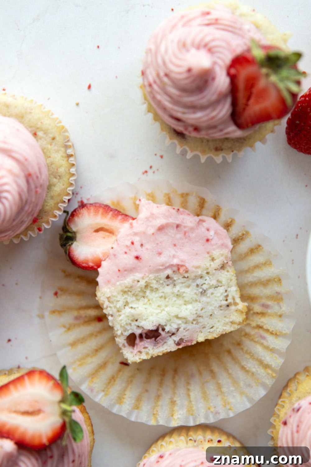 Strawberry Cream Cheese Cupcakes 6 Stack of strawberry cupcakes with cream cheese frosting, garnished with whole fresh strawberries