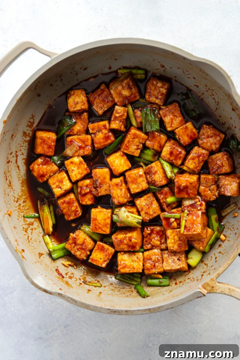 Close-up shot of crispy gochujang tofu bowls, highlighting the vibrant sauce, fluffy rice, and fresh pickled vegetables. A perfect vegetarian meal.