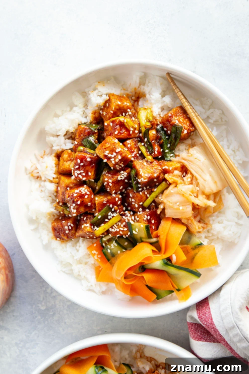 Close-up of gochujang tofu cubes being pan-fried until golden and crispy, before being tossed in the spicy sauce. Essential for crispy tofu bowls.