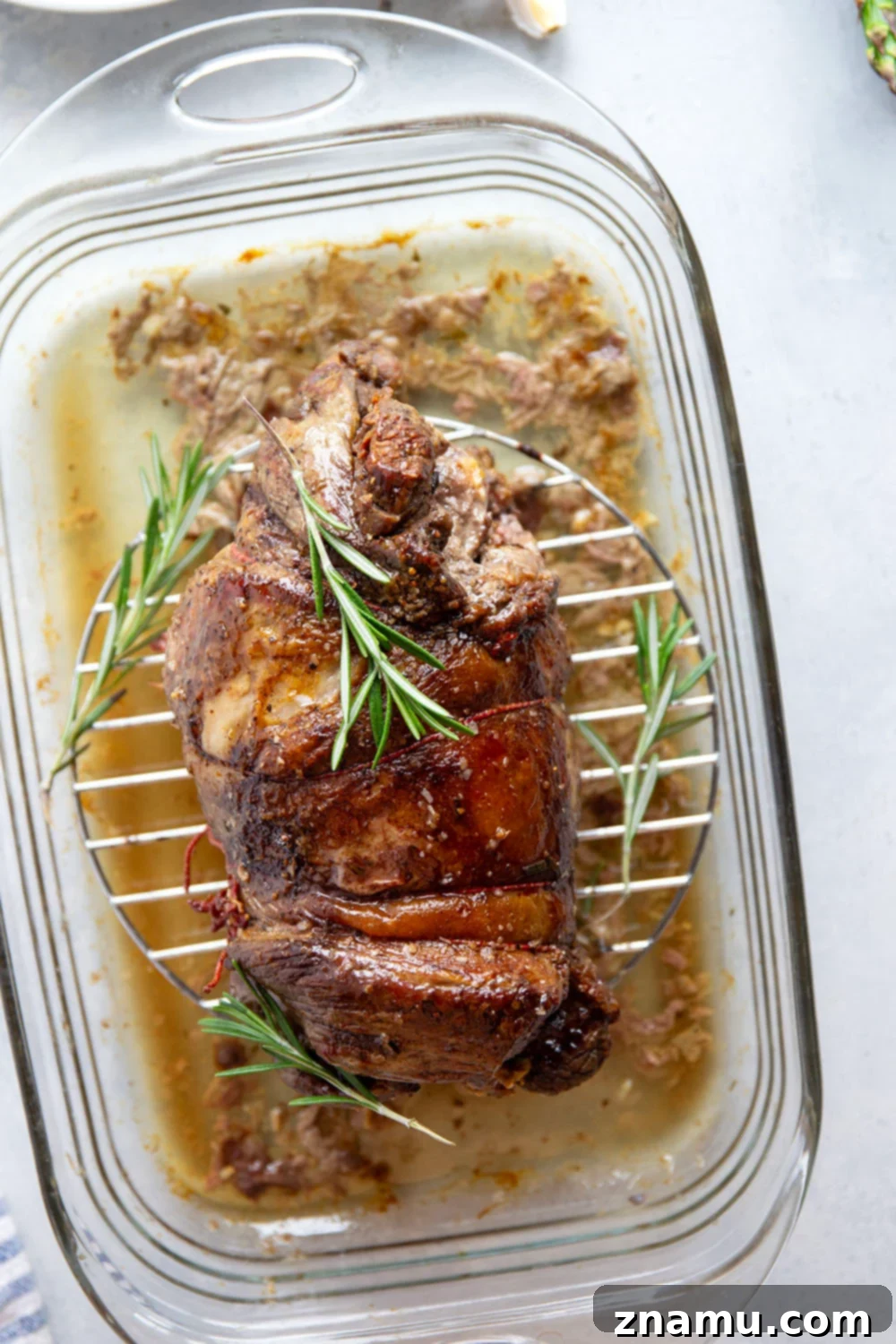 Aromatic Rosemary Garlic Leg of Lamb 3 A close-up of a perfectly cooked rosemary garlic leg of lamb, ready to be sliced and served.