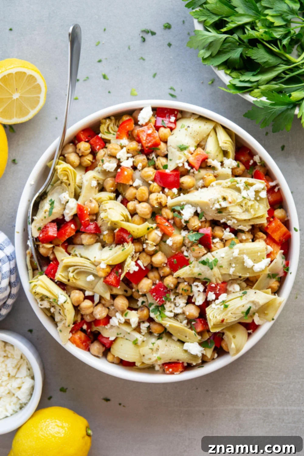 Zesty Artichoke and Crispy Chickpea Medley 6 A beautifully arranged serving of Crispy Chickpea Artichoke Salad in a rustic bowl, garnished with extra fresh parsley and feta. This inviting presentation emphasizes the vibrant colors and appealing textures, encouraging readers to try the recipe.