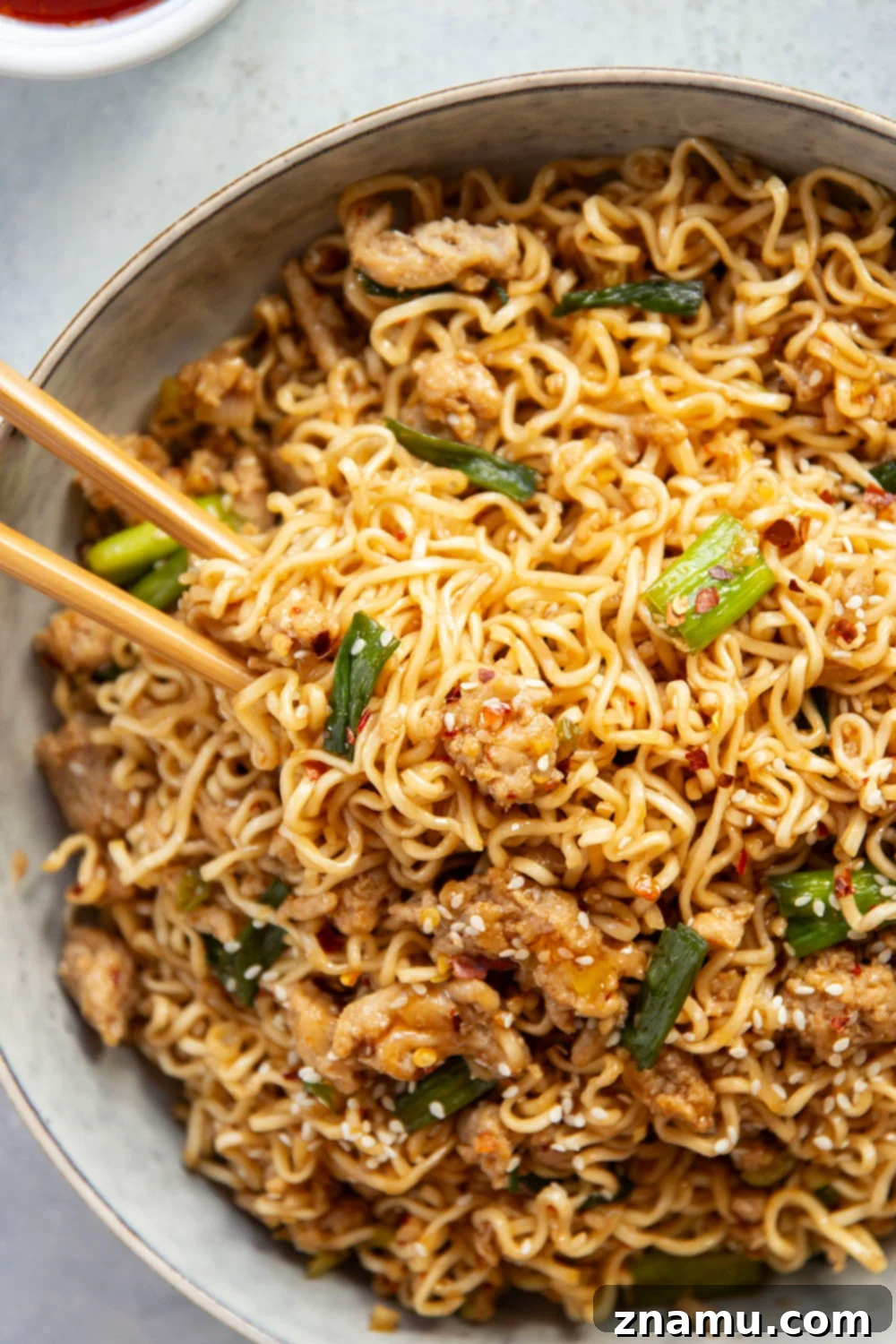 Sweet Chili Glazed Chicken Noodles 5 Ingredients for Sweet Chili Noodles laid out on a wooden board, including fresh ginger, garlic, green onions, and sweet chili sauce, preparing for a delicious Asian-inspired meal.
