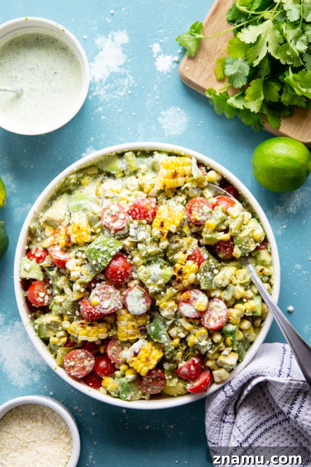 Smoky Poblano Corn Salad with Fresh Cilantro Crema 5 A cutting board with charred poblano peppers and corn on the cob, ready for preparation.