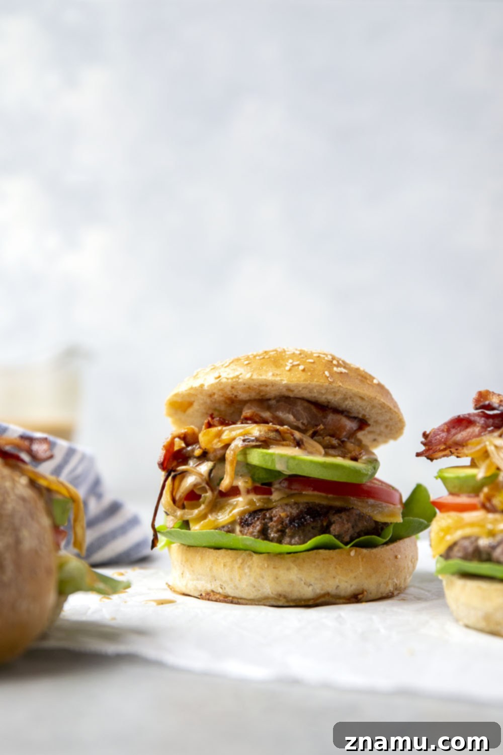 Hearty Cowboy Stack 5 A perfectly grilled beef patty topped with melted cheese, nestled on a toasted bun with lettuce and a generous dollop of special sauce, ready for more toppings.