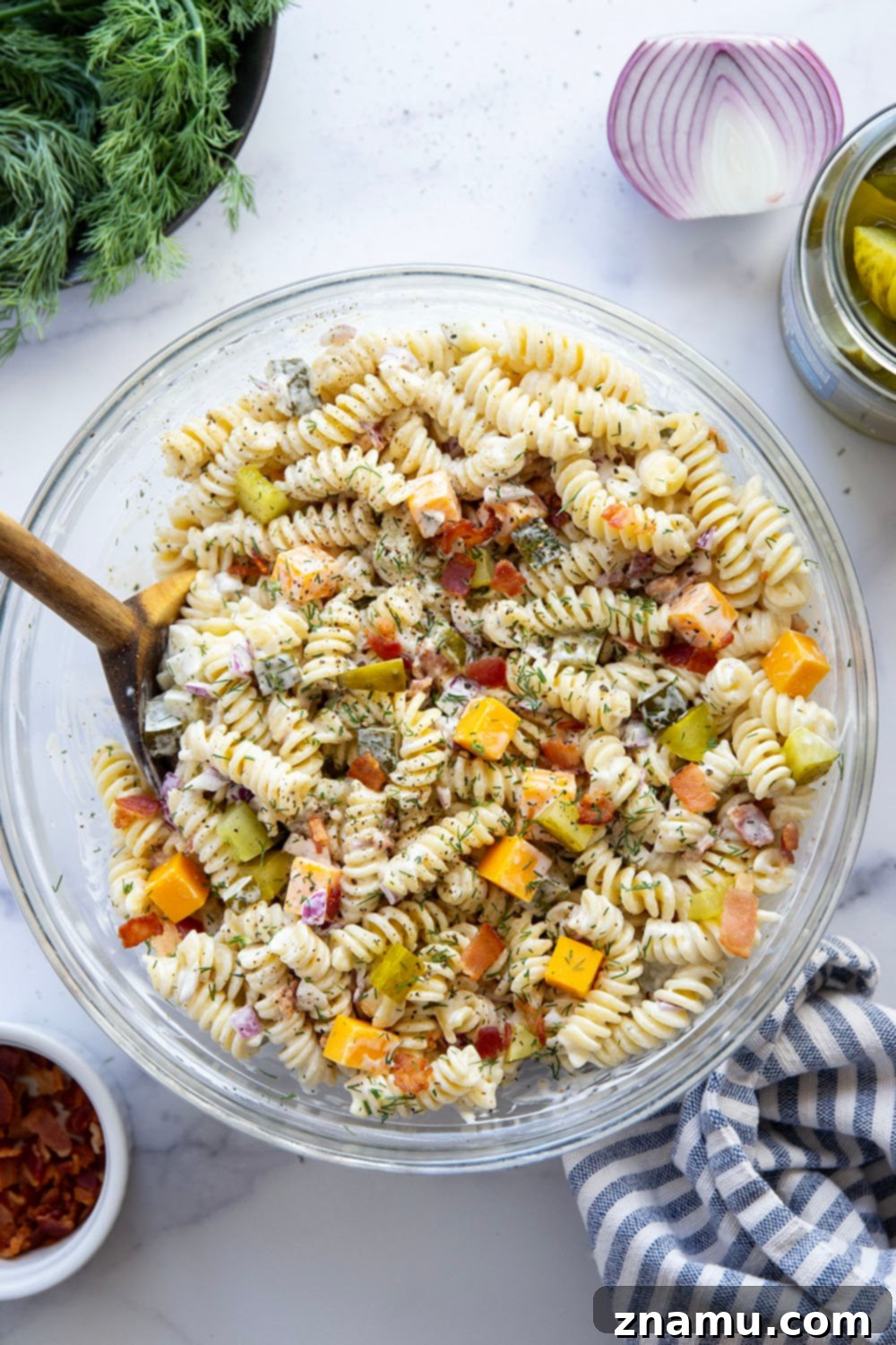 Zesty Bacon Dill Pasta Salad 5 Close-up of a serving of dill pickle pasta salad, showcasing the texture of the pasta, bacon, and cheese.