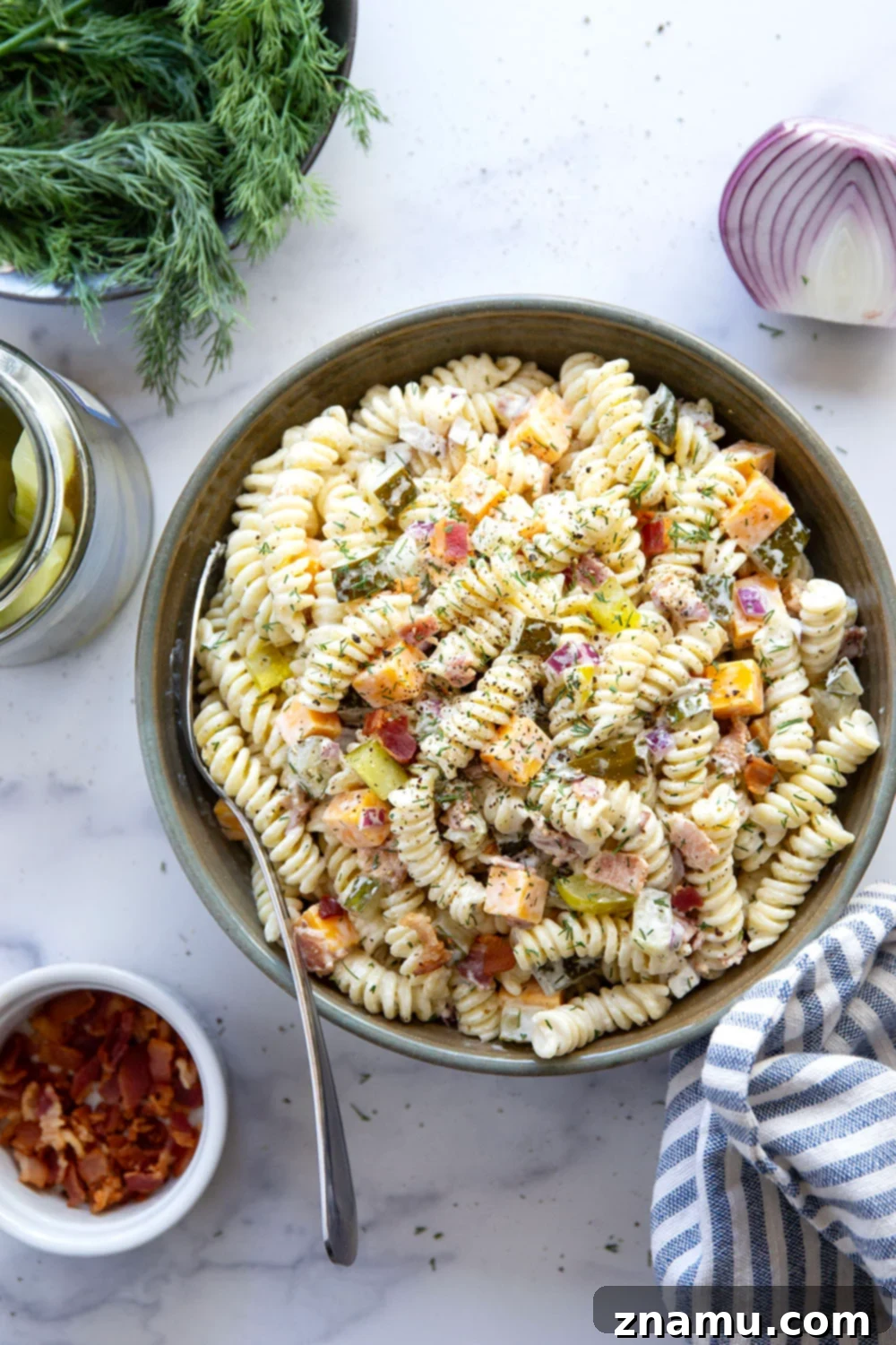 Zesty Bacon Dill Pasta Salad 6 Fresh dill sprigs adorning a vibrant dill pickle pasta salad, highlighting its fresh ingredients.