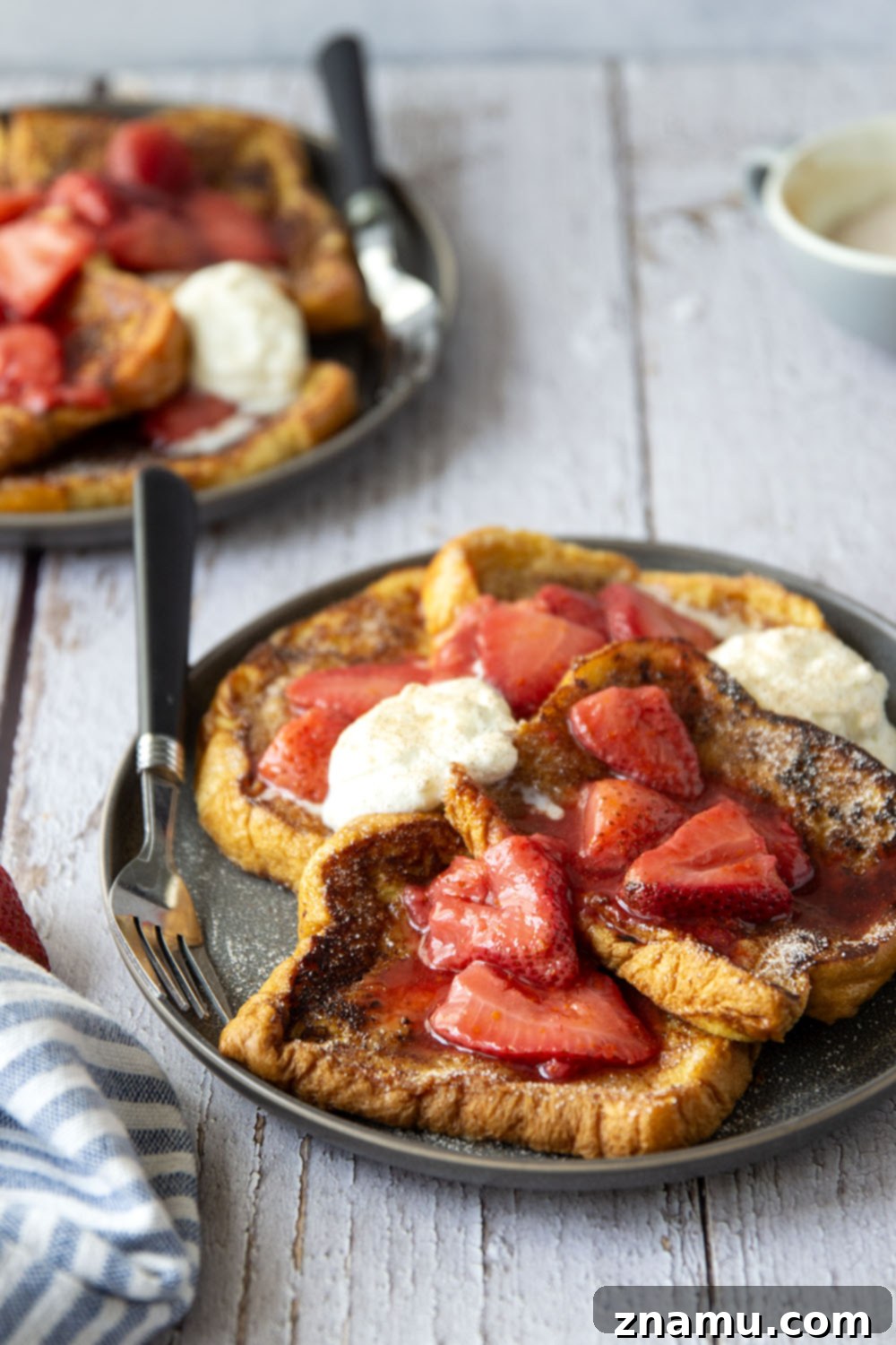Golden Cinnamon Sugar French Toast with Zesty Strawberry Orange Sauce 4 Platter of golden Cinnamon Sugar French Toast topped generously with strawberry orange sauce and whipped cream.