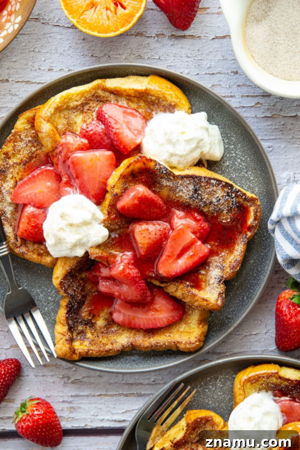 Golden Cinnamon Sugar French Toast with Zesty Strawberry Orange Sauce 5 Hands preparing Cinnamon Sugar French Toast slices on a griddle, showing the golden-brown perfection.