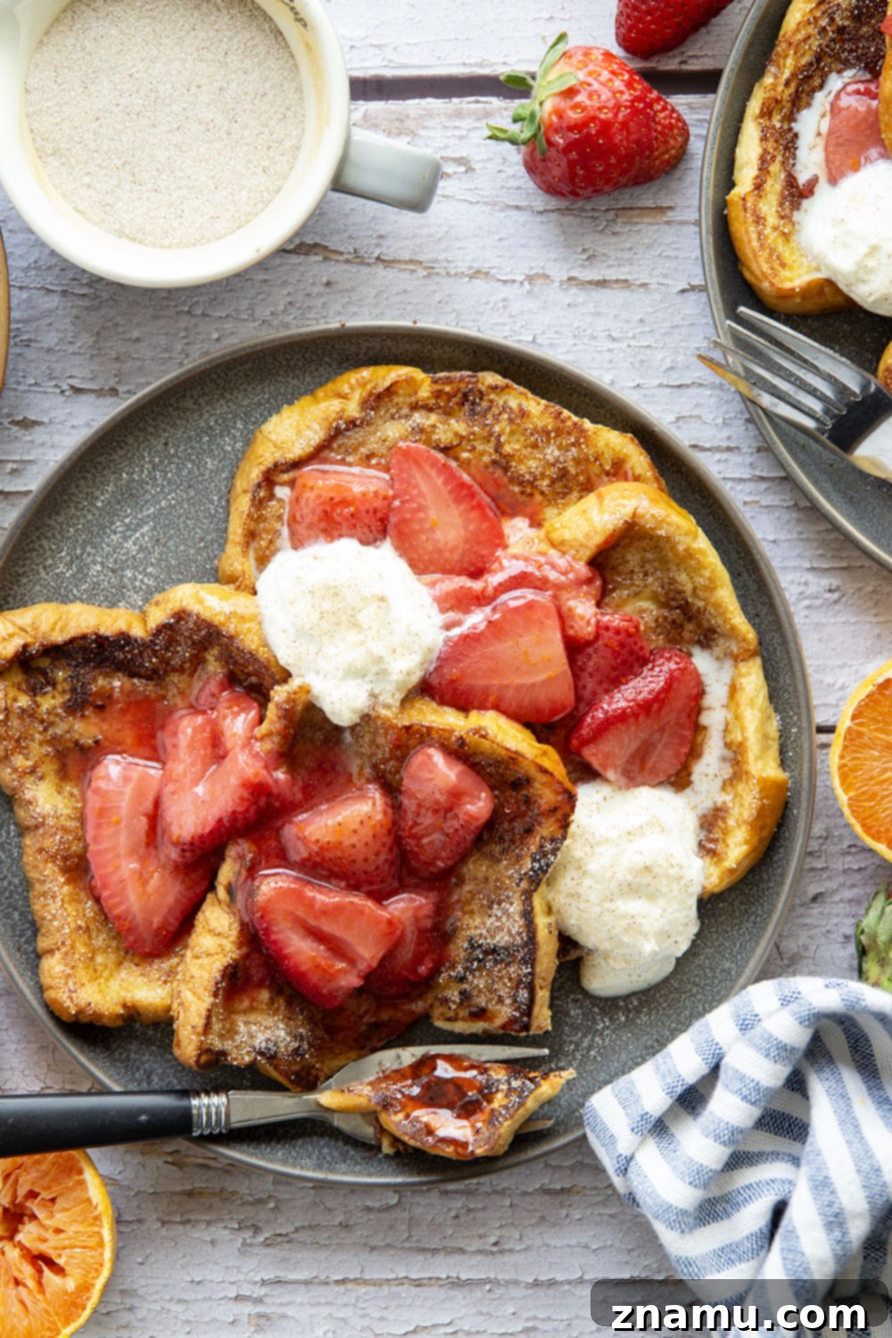 Golden Cinnamon Sugar French Toast with Zesty Strawberry Orange Sauce 6 Close-up of Cinnamon Sugar French Toast stack with generous topping of strawberry orange sauce and a dollop of whipped cream.