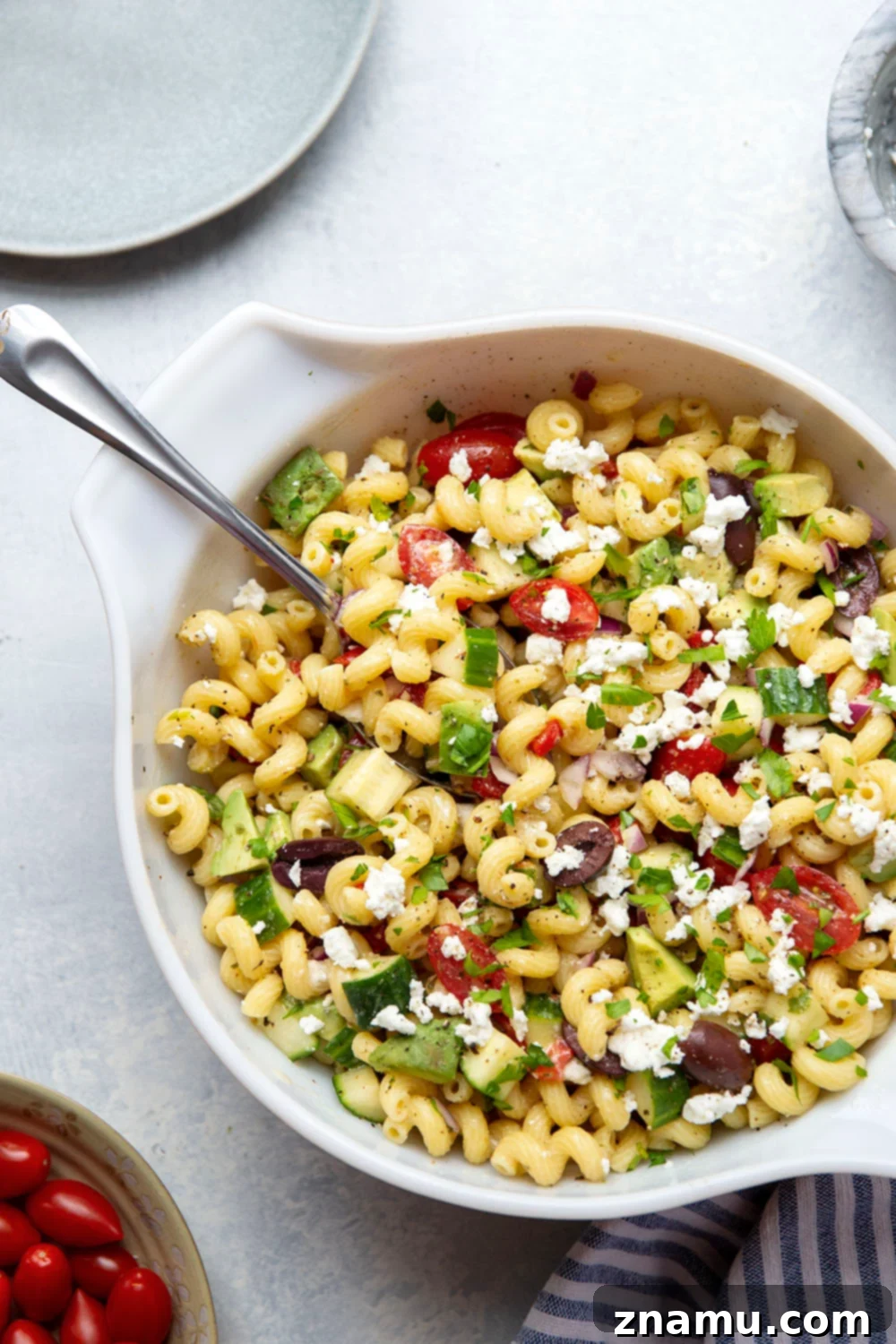 Mediterranean Sunshine Pasta 2 A vibrant Greek pasta salad with tender pasta, fresh vegetables, feta, and olives, dressed in a lemon herb vinaigrette, served in a large bowl.
