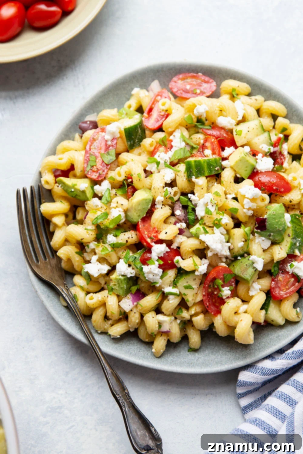 Mediterranean Sunshine Pasta 4 Bowl of fresh ingredients for Greek pasta salad, including chopped vegetables, feta, and olives.