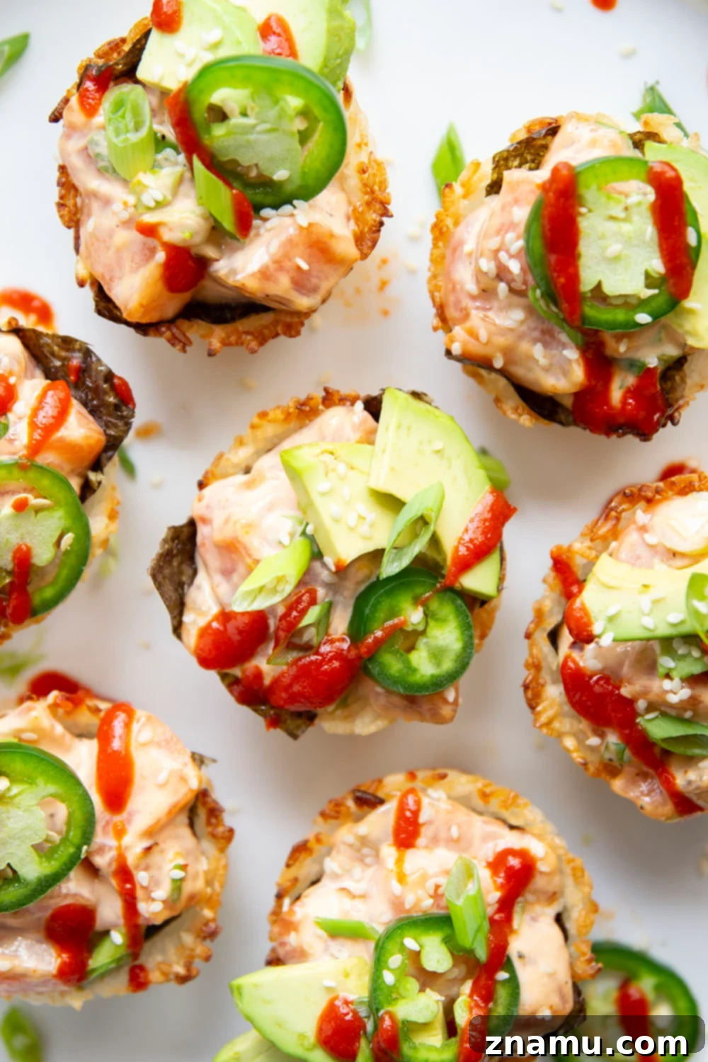 Spicy Salmon Sushi Bites 2 These spicy salmon sushi cups feature crispy rice cups filled with a spicy sriracha salmon filling and topped with lots of fresh avocado and jalapeno.
