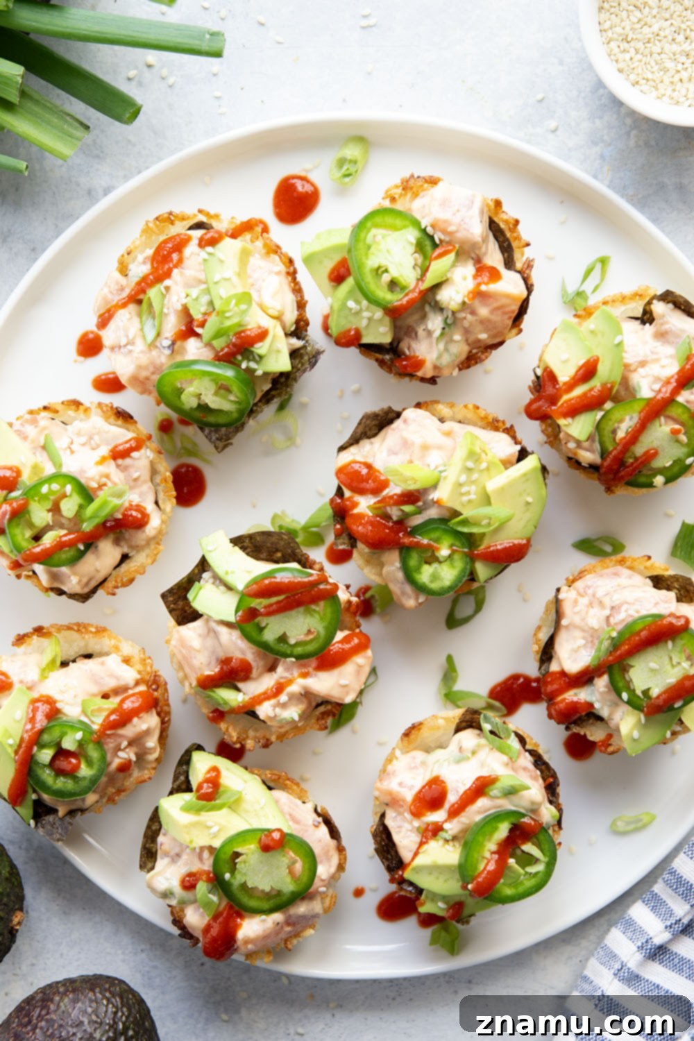 Spicy Salmon Sushi Bites 3 These spicy salmon sushi cups feature crispy rice cups filled with a spicy sriracha salmon filling and topped with lots of fresh avocado and jalapeno.