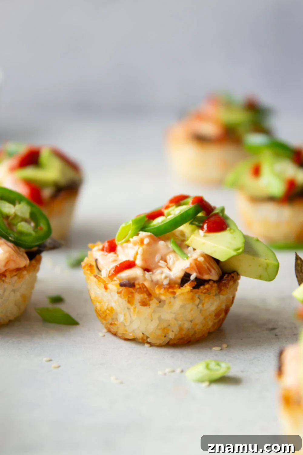 Spicy Salmon Sushi Bites 6 These spicy salmon sushi cups feature crispy rice cups filled with a spicy sriracha salmon filling and topped with lots of fresh avocado and jalapeno.