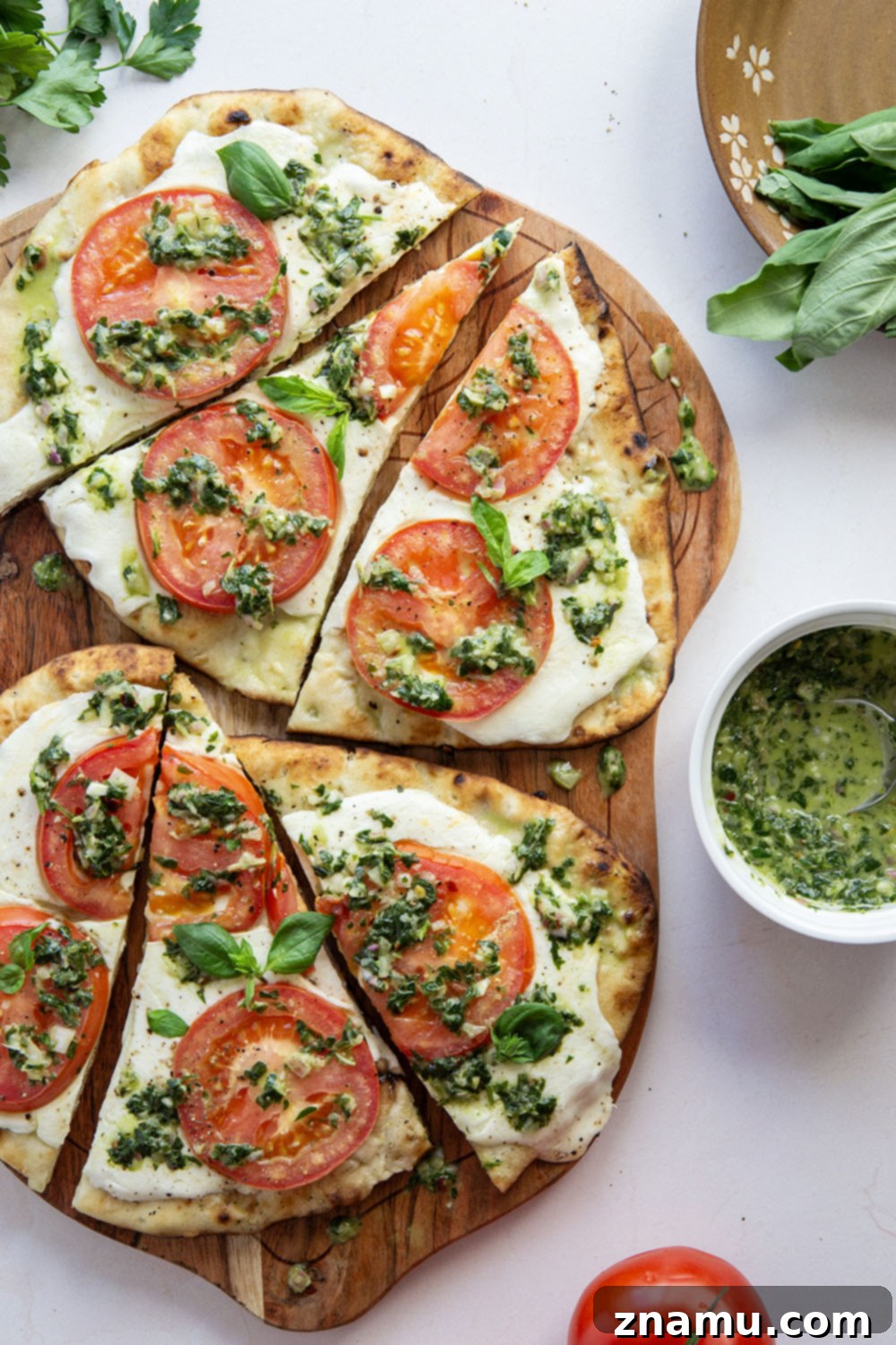 Fire-Kissed Caprese Flatbread with Aromatic Basil Chimichurri 6 A perfectly grilled Caprese flatbread on a rustic wooden board, topped with vibrant green basil chimichurri.