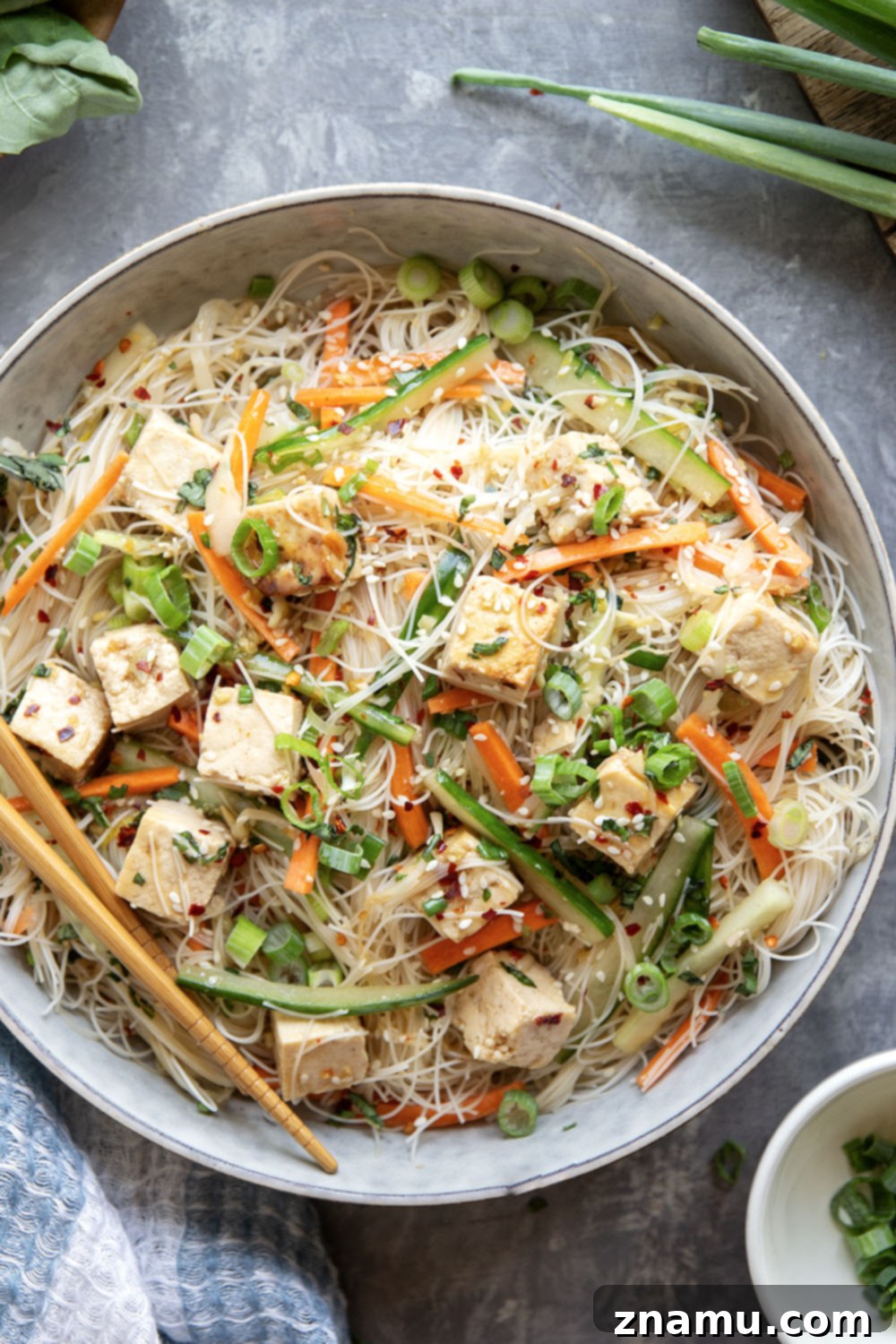 A large serving bowl filled with the colorful Vermicelli Noodle Salad, garnished with sesame seeds and fresh basil, ready to be enjoyed.