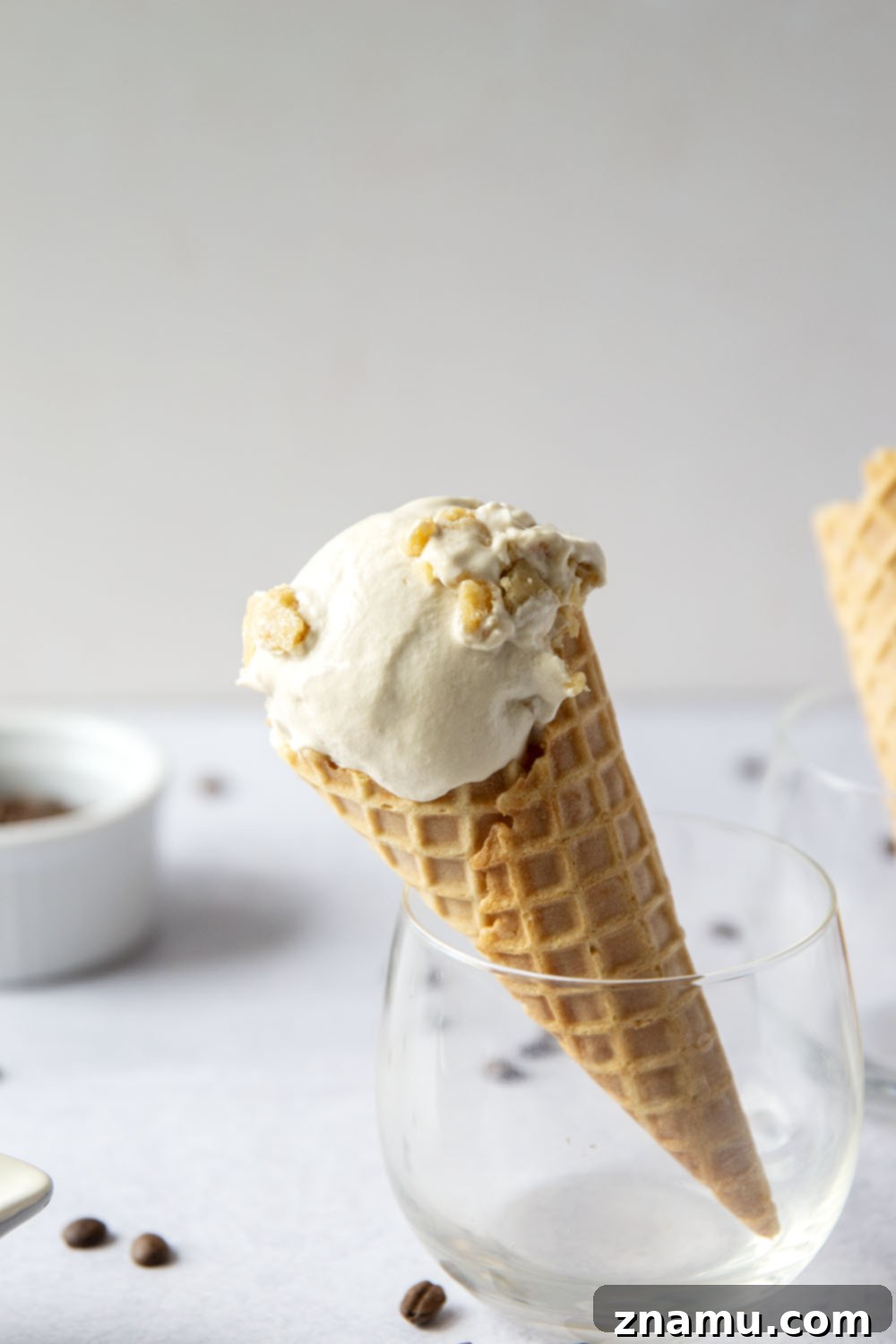 Toffee Espresso Chill 4 A scoop of no-churn espresso ice cream with toffee bits in a white bowl, ready to be enjoyed.