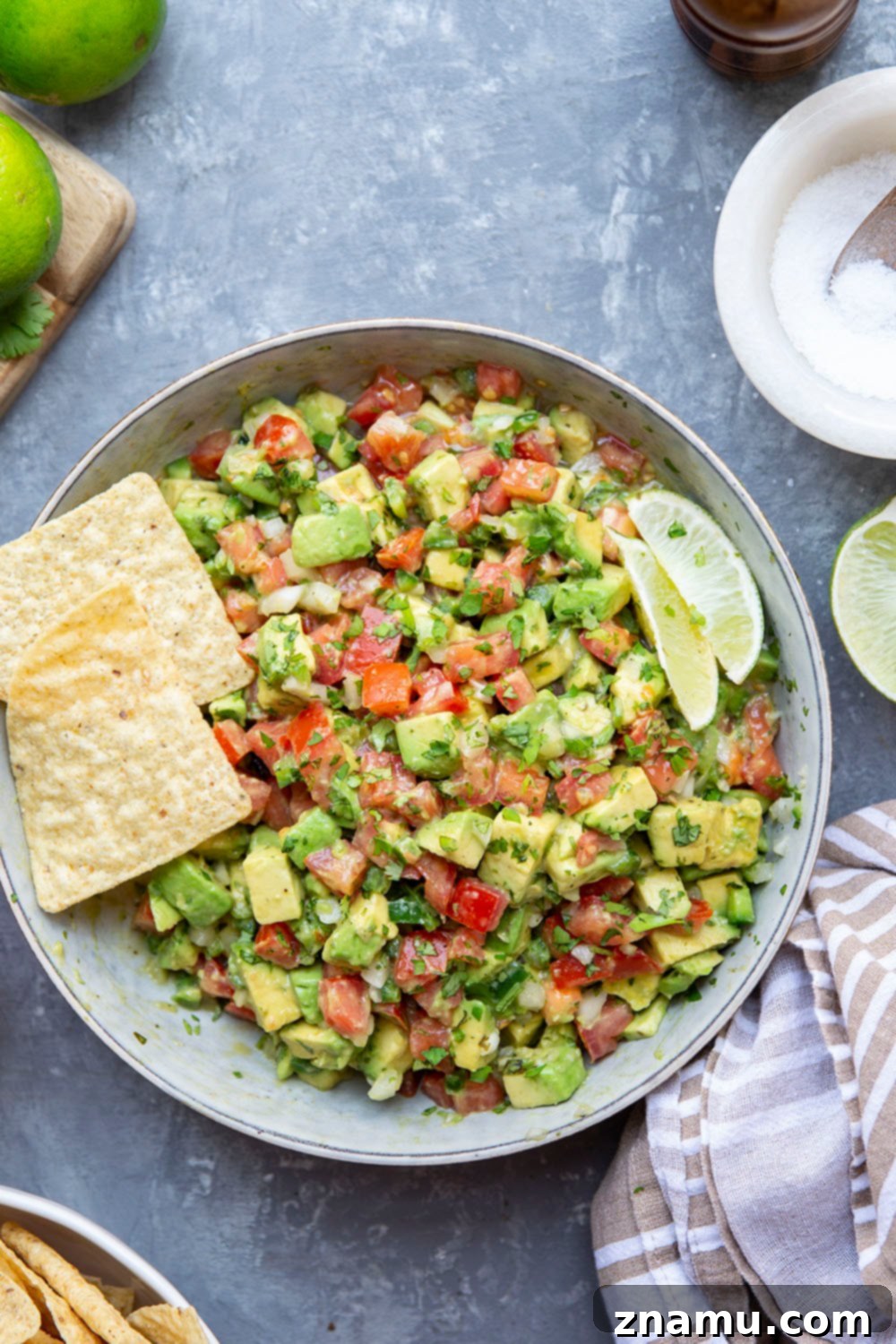 The Ultimate Chunky Avocado Salsa 2 A beautifully presented bowl of chunky avocado salsa, brimming with diced avocados, tomatoes, red onion, cilantro, and lime, ready to be scooped with tortilla chips. This vibrant dip offers the best of both guacamole and salsa.
