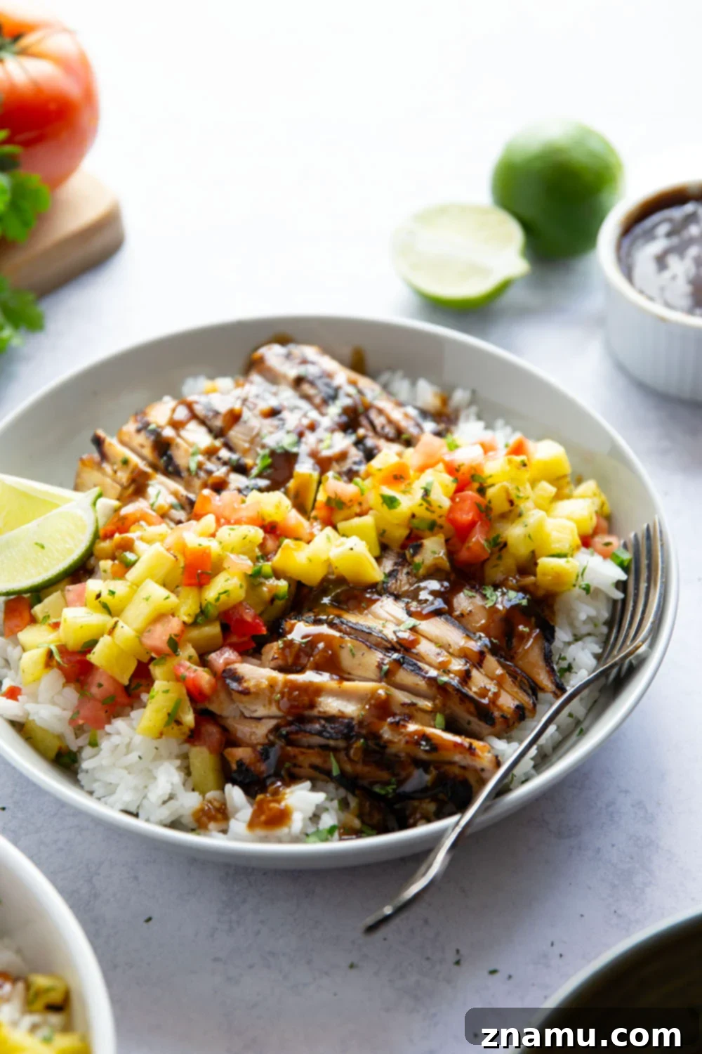 Close-up of grilled pineapple chicken with vibrant salsa and rice.