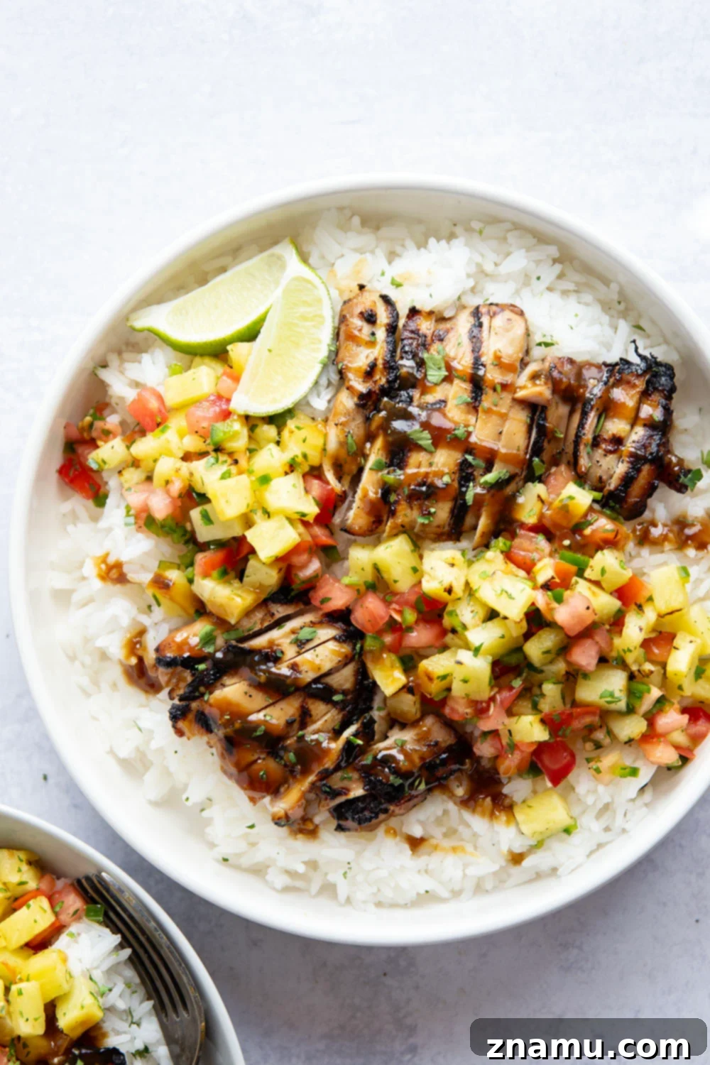 Delicious grilled pineapple chicken and rice bowls with fresh herbs.