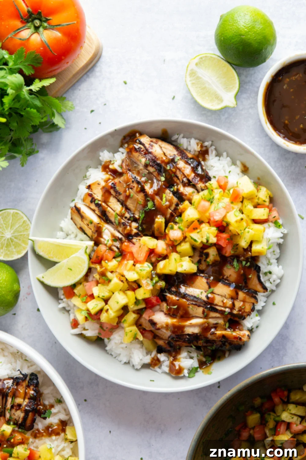 Stacked grilled pineapple chicken and rice bowls ready to be served.