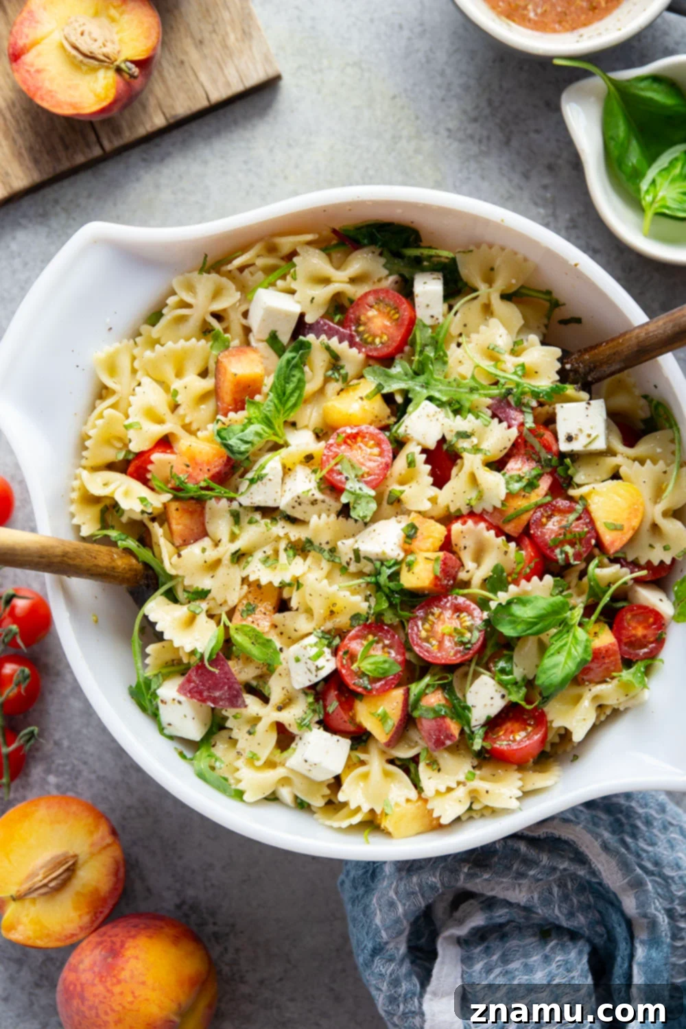 Golden Peach Caprese Pasta 2 Sweet peaches pair perfectly with herby basil, soft mozzarella, juicy cherry tomatoes, and a tangy balsamic dressing in this peach caprese pasta salad.