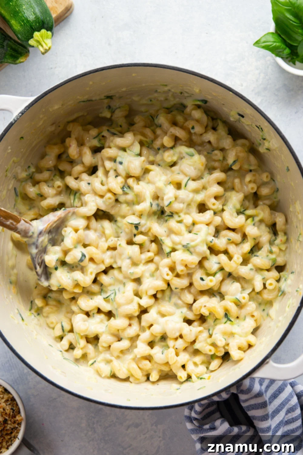 Creamy One-Pot Zucchini Mac and Cheese 3 Close-up of a spoonful of creamy zucchini mac and cheese with melted cheese and pasta.
