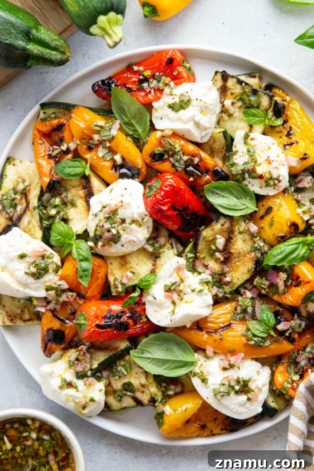 Smoky Grilled Vegetables, Creamy Burrata, Zesty Chimichurri 5 A close-up shot of grilled zucchini and mini sweet peppers, ready to be served.