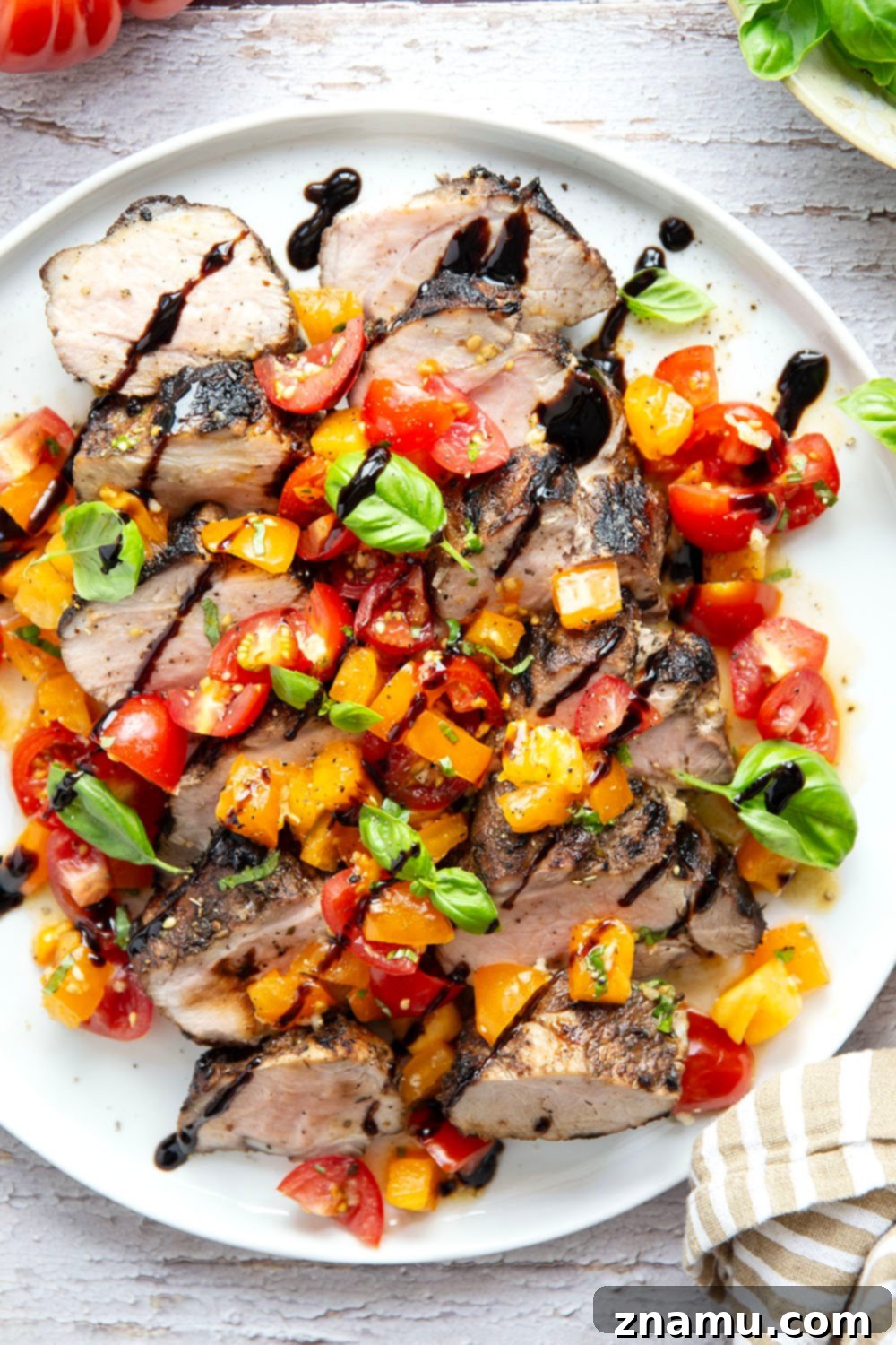 Grilled Pork Loin with Zesty Bruschetta 3 Perfectly grilled pork loin slices with vibrant bruschetta topping