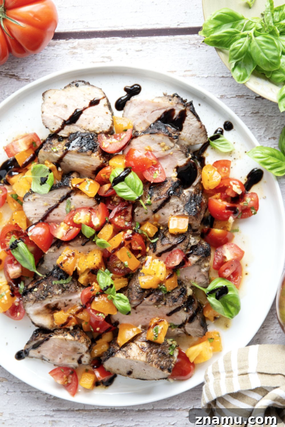 Grilled Pork Loin with Zesty Bruschetta 6 Oven-baked pork loin resting before slicing, ready for bruschetta topping
