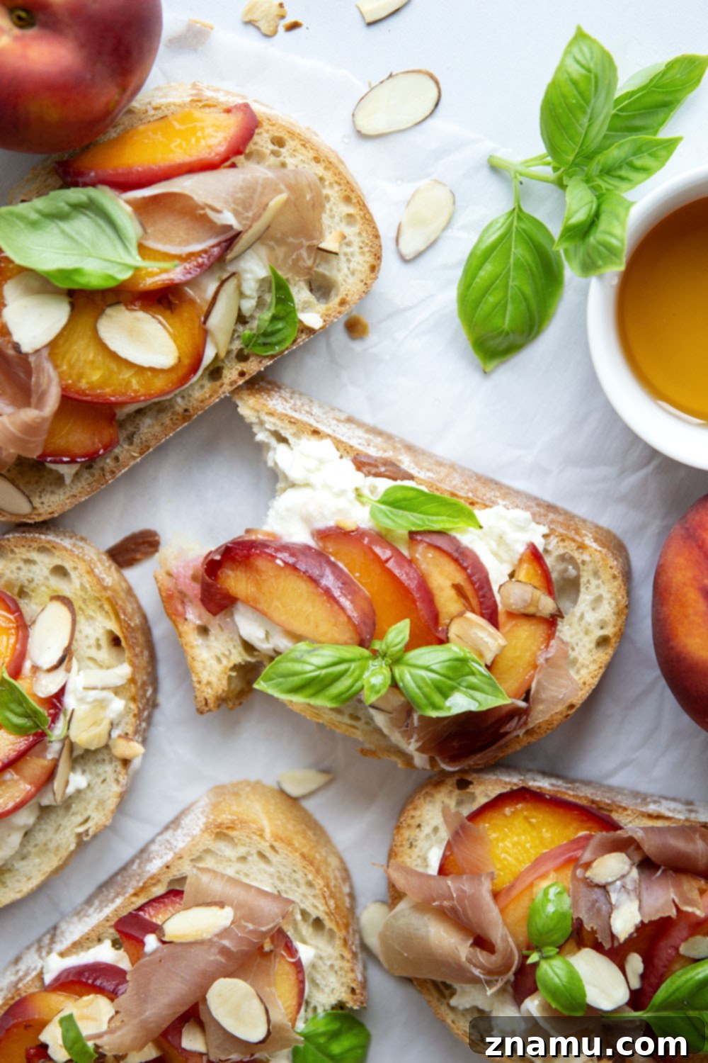 Burrata Toast with Honey Roasted Peaches 6 Multiple slices of Honey Roasted Peach Burrata Toast with basil and prosciutto, ready to serve.