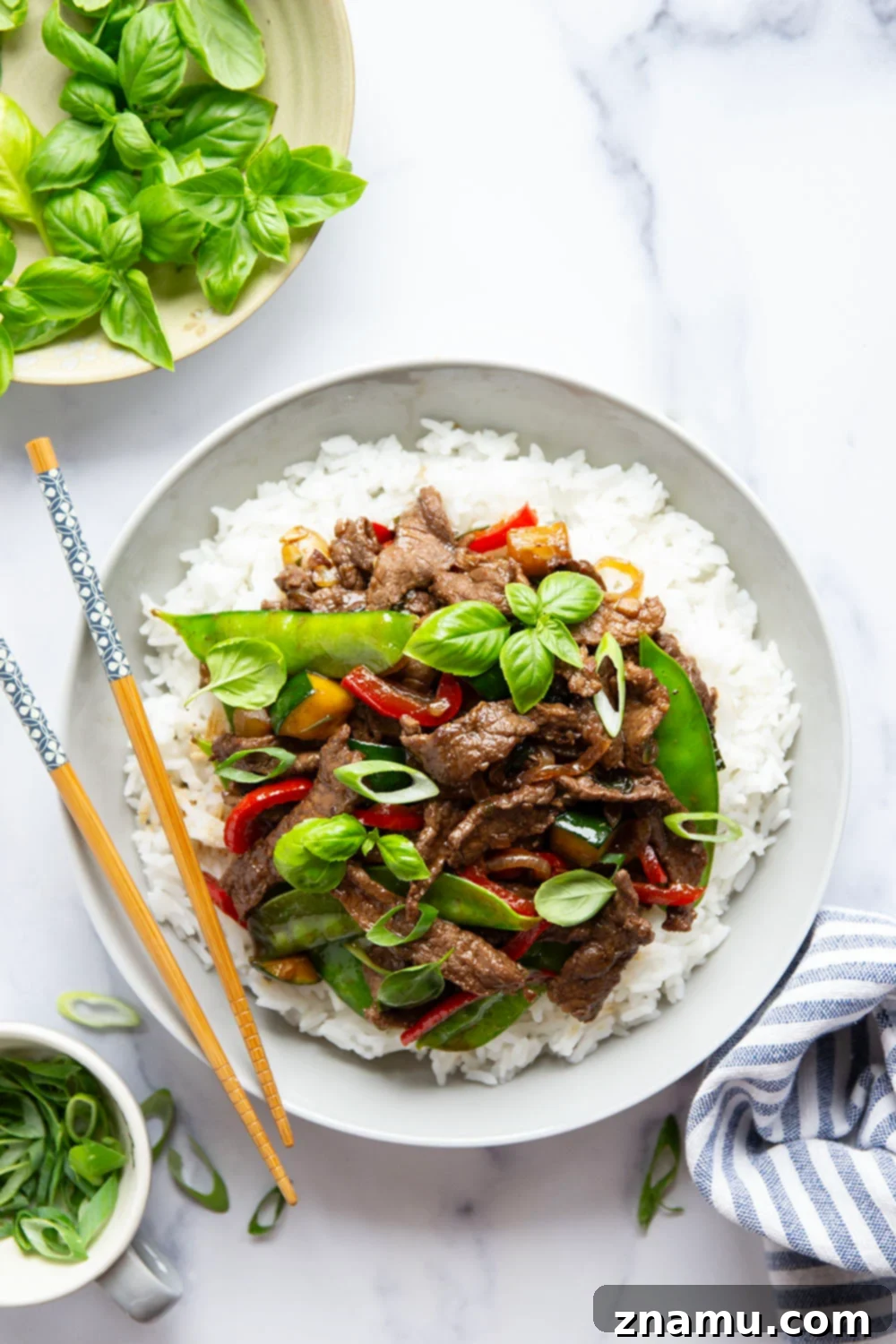 Wok-Fired Thai Basil Beef 3 This Thai basil beef stir fry features juicy seared steak strips in a savory sauce with lots of tender vegetables and fresh basil.
