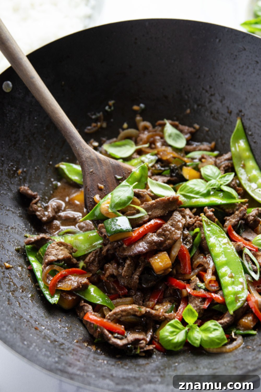 Wok-Fired Thai Basil Beef 4 This Thai basil beef stir fry features juicy seared steak strips in a savory sauce with lots of tender vegetables and fresh basil.