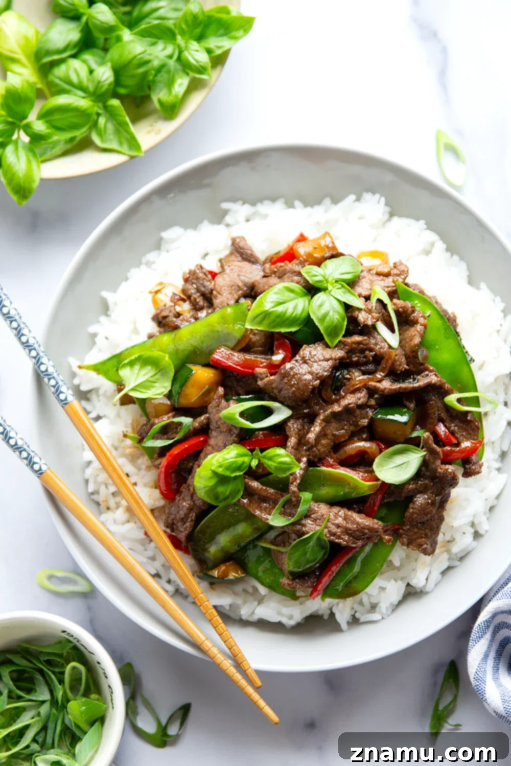 Wok-Fired Thai Basil Beef 5 This Thai basil beef stir fry features juicy seared steak strips in a savory sauce with lots of tender vegetables and fresh basil.