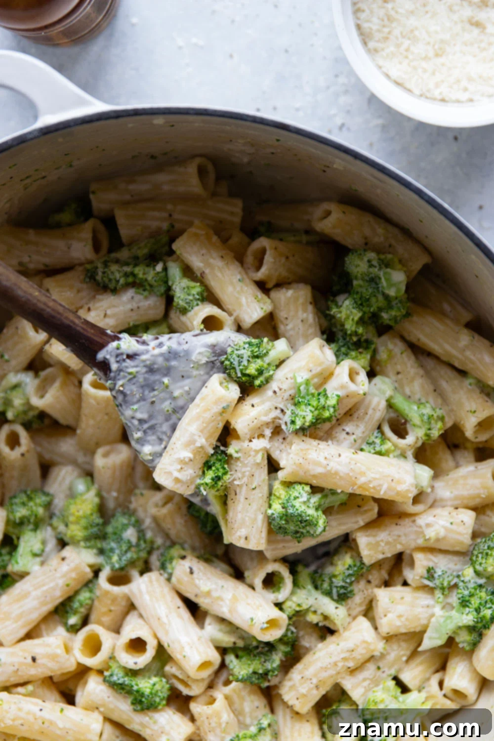 Velvety Parmesan Broccoli Pasta 6 A large serving of creamy Parmesan broccoli pasta in a pot with serving spoon