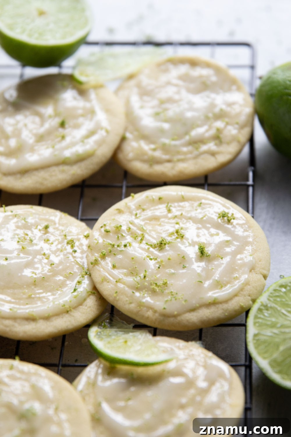 Zesty Lime Cream Cheese Tea Cakes 6 Close-up of a stack of lime tea cakes with creamy frosting and lime zest garnish