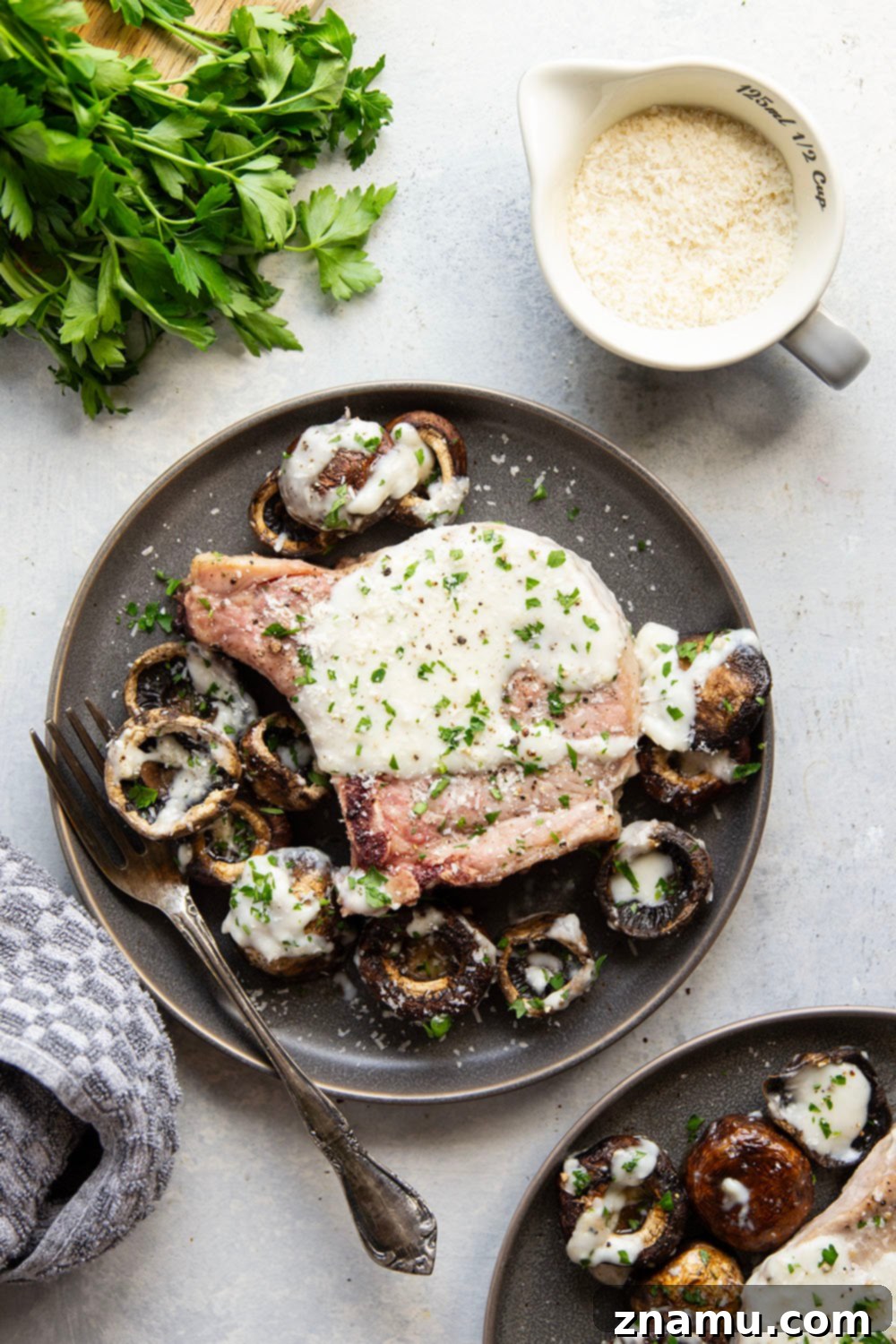 Garlic Parmesan Pork Chops and Mushrooms Plated with Creamy Sauce