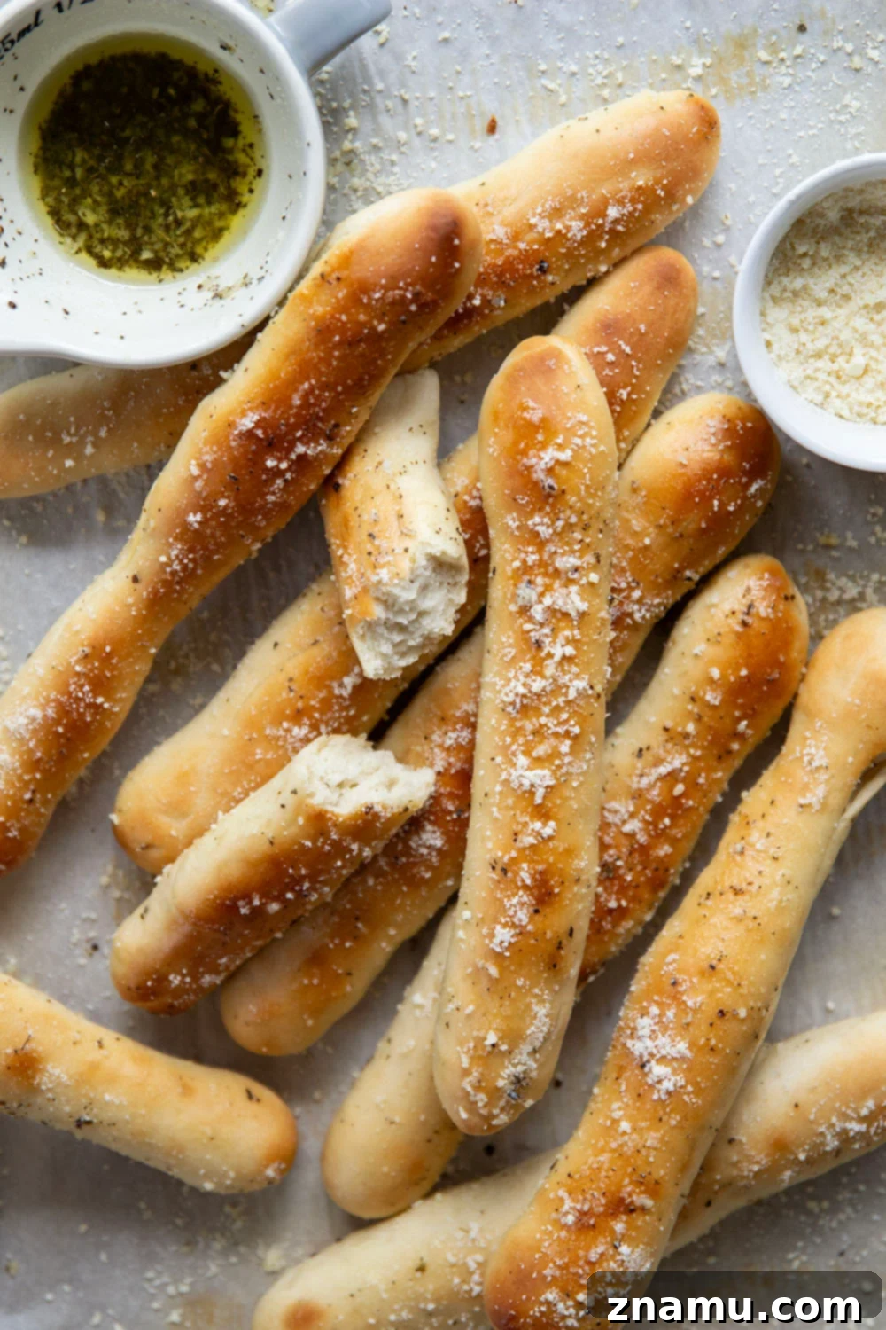 Irresistible Homemade Breadsticks 6 A basket full of golden homemade breadsticks, ready to be served, brushed with garlic butter and Parmesan.