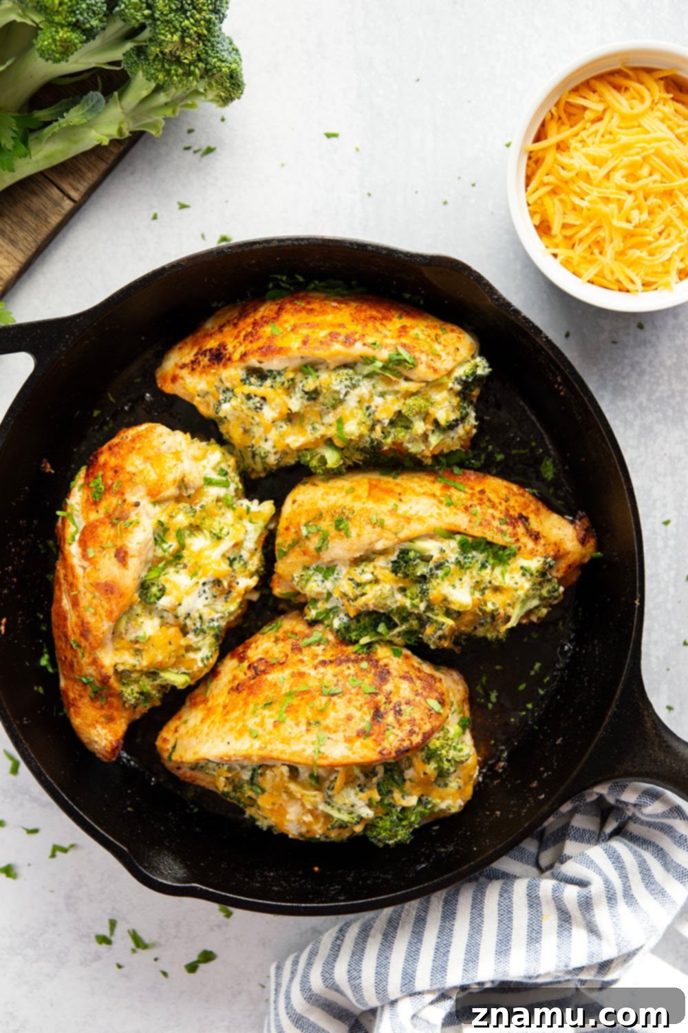 Broccoli and Cheese-Filled Chicken Breast 5 The vibrant ingredients for broccoli cheese stuffed chicken, including fresh broccoli, cheeses, spices, and chicken breasts.