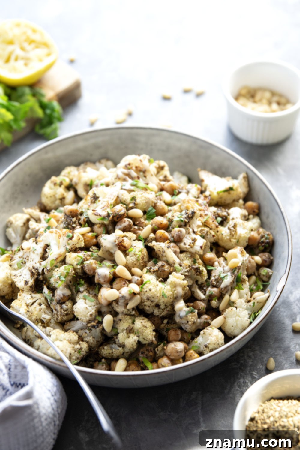 Za'atar Roasted Cauliflower & Chickpea Delight 4 A vibrant platter of Za'atar Roasted Cauliflower and Chickpeas, garnished with fresh parsley and toasted pine nuts.